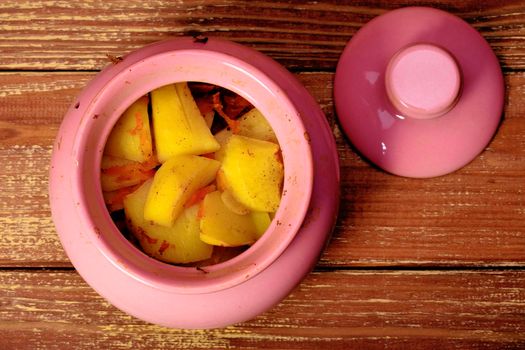 Pink pot with stew potatoes top view.
