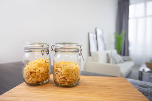 Jars of pasta on the background of the apartment.