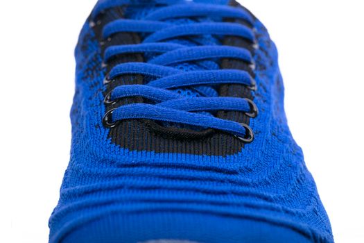 Part of a blue sneaker made of fabric with laces. A fragment of sports shoes.