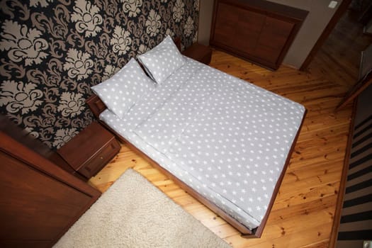 Interior of a small bedroom with a top view bed.