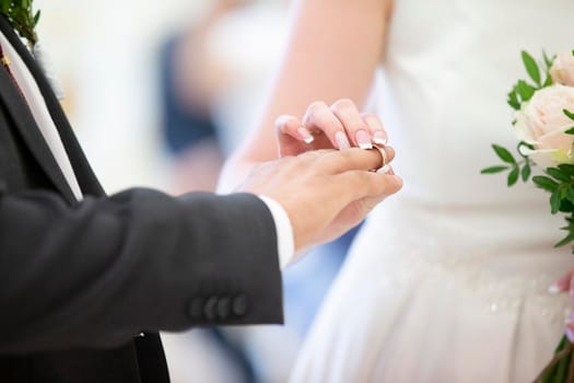 Wedding day. The bride dresses the ring to the groom. Hands of the newlyweds.