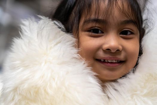 Pretty asian child wearing a white coat made of fur. Pretty asian model wearing white fur coat