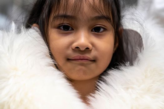 Pretty asian child wearing a white coat made of fur. Pretty asian model wearing white fur coat