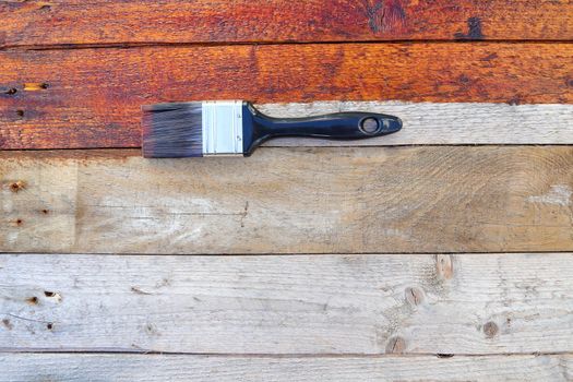 Rustic old wood surface sealant treatment with paintbrush flat-lay, South Africa