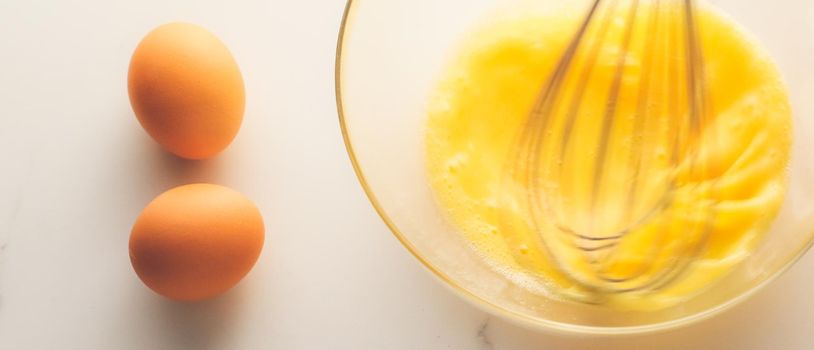 Cooking, meal and diet concept - Making of mixing eggs in bowl on marble table as homemade food flat lay, top view food brand photography flatlay and recipe for cooking blog, menu or cookbook design