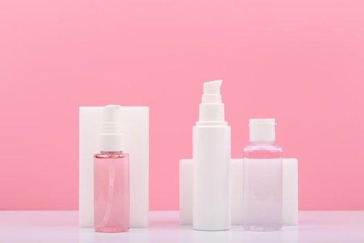 Set of cosmetic bottles with beauty products for regular skin care against pink background. Skin foam or lotion, face cream and tonic for anti aging or anti acne treatment