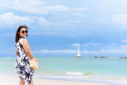 Landscape of the beach and the sea in summer sky and beautiful woman tourist wearing sunglasse, looking at the camera and smiling on Tarutao island, Satun, Thailand