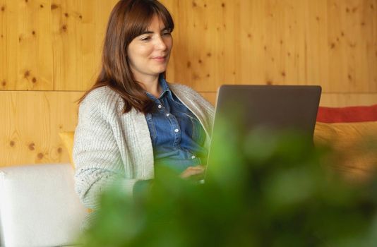 Woman working on a laptop on a cozy space