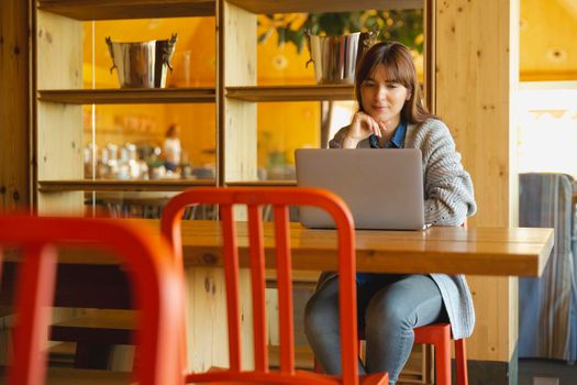 Woman working on a laptop on a cozy space