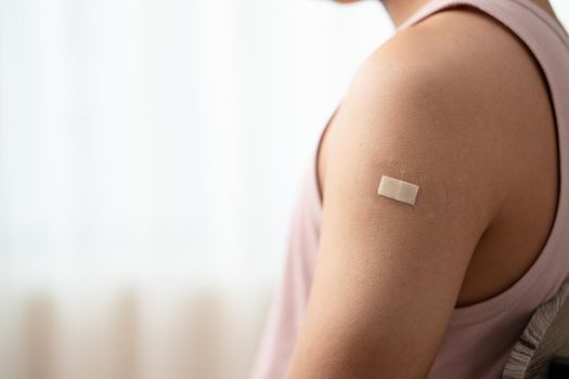 Man with bandage showing his arm after receiving vaccine.