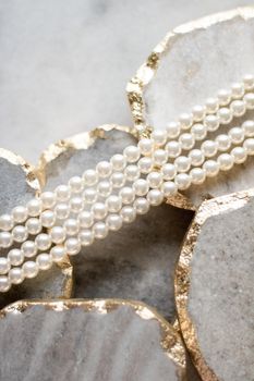 Pearl necklace on golden marble, ethical jewellery - luxury background, jewelry as a gift concept. Pearls are girl's best friends