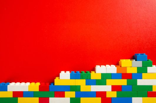 Plastic building blocks on red background