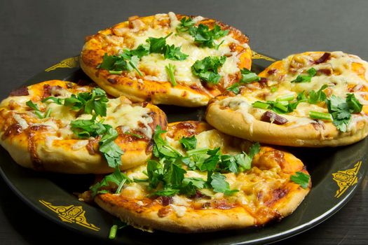 Small pizzas on a black plate