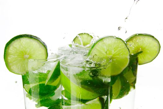 Making mojito cocktails with lime and mint isolated on white background