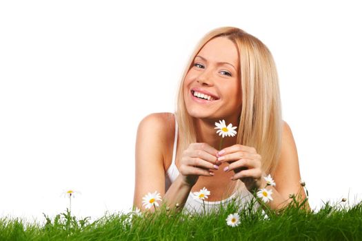 Happy young woman lying on grass with chamomile flowers, isolated on white background