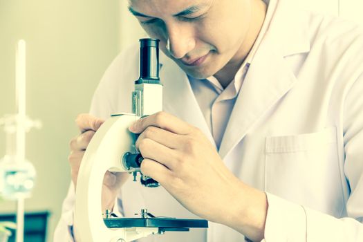 Asian scientists or chemists use a microscope. In science experiment Medical pharmaceutical research concept DNA structure, innovation and technology