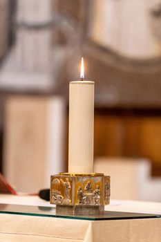 large candle lit for a church ceremony
