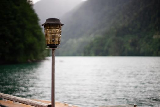 Antique glass and metal lantern on the background of the Ritsa lake. Abkhazia
