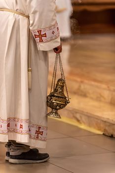 priest holding an incense pot during a church ceremony