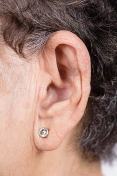 closeup senior woman's ear with earring, healthcare and medical concept