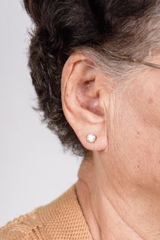 closeup senior woman's ear with earring, healthcare and medical concept