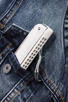 isolate silver/white harmonica in denim pocket, music instrument