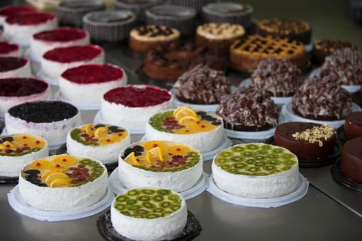 Cake and baking line.Industrial line of cakes. Many beautiful cakes on the table.Multicolored culinary products