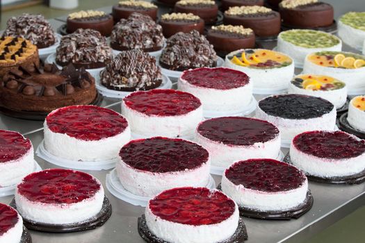 Cake and baking line.Industrial line of cakes. Many beautiful cakes on the table.Multicolored culinary products