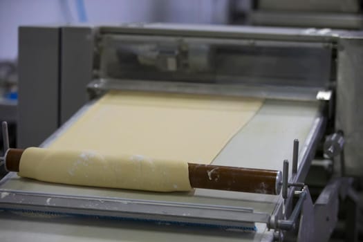 Industrial production of culinary products and bread.Yeast dough on the bread baking line