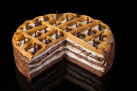 A piece of chocolate cake with white cream on a black background