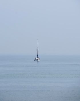 Sailboat in the ocean on cloudy day, no horizon, isolated, no contrast