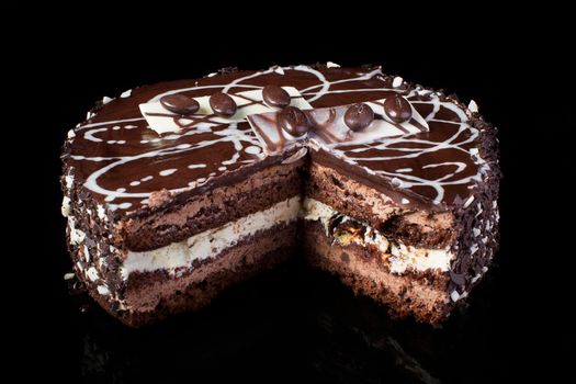 A slice of chocolate cake with coffee beans on a black background
