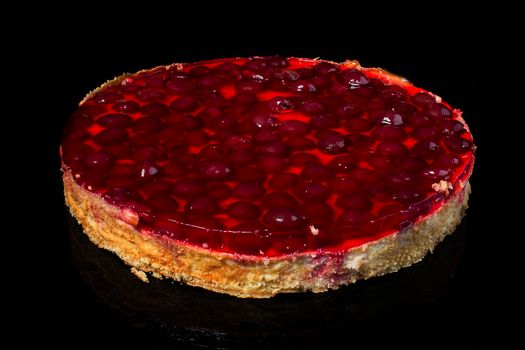 Cake cheesecake with cherry in jelly on black background
