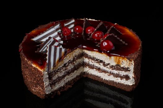 A piece of chocolate cake with white cream on a black background