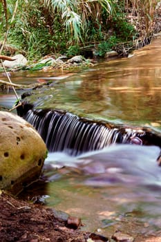 Small waterfall in a mountain river, transparent water, long exposure,