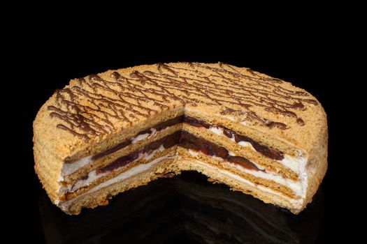 A piece of shortcake cake covered with peanuts on a dark background