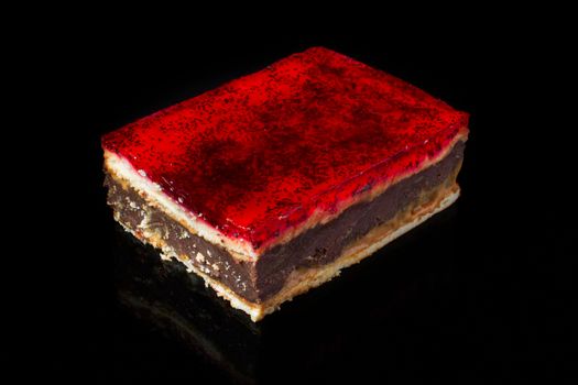 Chocolate cake with red jelly cream on a black background