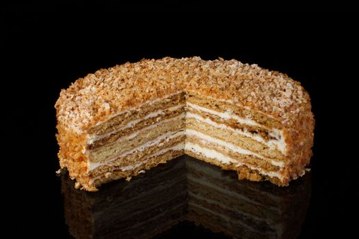 A piece of shortcake cake covered with peanuts on a dark background