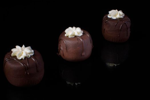 Small chocolate cakes on a black background.Brownie.Russian Potato Cake