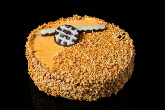 An ordinary cake covered with peanuts on a black background