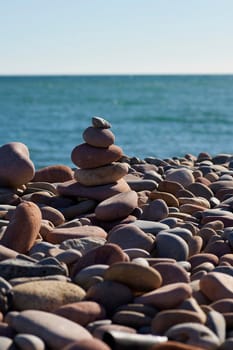 Small mountain of three rocks, lonely, background out of focus, surrounded by small rocks