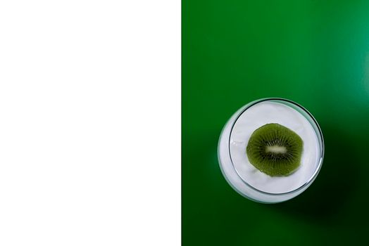 Yoghurt cup with kiwi on green and white background, rectangles, horizontal, symmetry