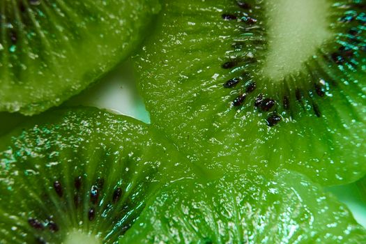 Section of cut ripe kiwifruit. Macro photograph, detail, green, seeds, white