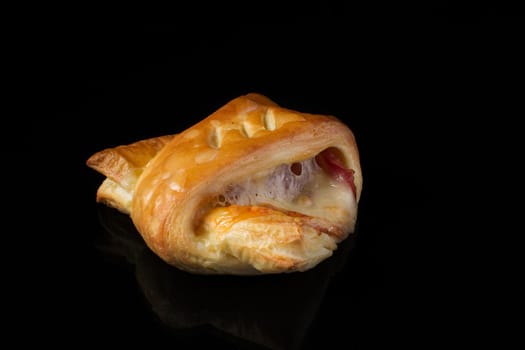 Puff pastry with meat and cheese on a dark background