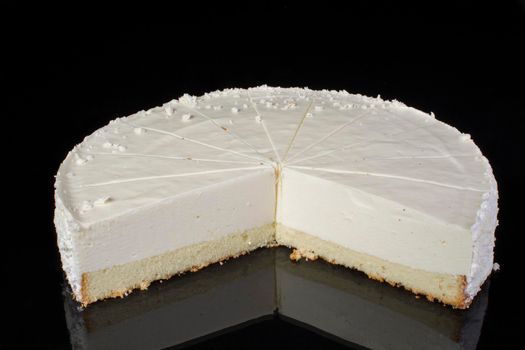 Cake cheesecake sliced in portions on a black background