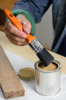 closeup the man hand using paintbrush to painting the wood plank