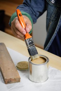 closeup the man hand using paintbrush to painting the wood plank