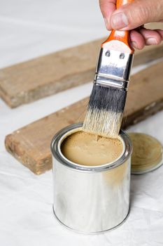 closeup the man hand using paintbrush to painting the wood plank