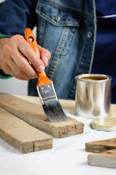 closeup the man hand using paintbrush to painting the wood plank