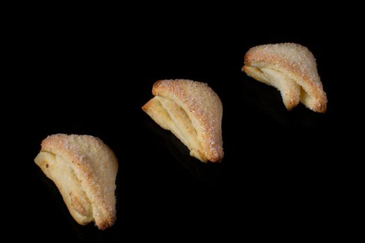 Cookies from a puff pastry triangle on a black background